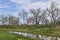 A full Creek runs lazily through a Sub division at Richmond Texas, with grassy Backyards and wooden fencing.