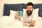 Full of energy. Coffee affects body. Man handsome hipster relaxing on bed with coffee cup. Bearded hipster enjoy morning