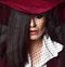 Full-face portrait of mysterious lady brunette in dark red hat with her veil down