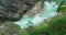 Full-flowing mountain stream in rocky gorge. Spring clear water in ravine. Shooting during heavy rain.