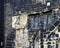 a full frame close up of ancient stonework stained glass windows and a sundial on the medieval church of st john the baptist in