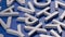 full frame close-up looped rotating background of silver metal letters on flat blue painted surface