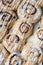 Full-frame diagonal rows of cinnamon rolls drizzled with frosting