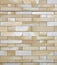 Full frame image of a wall made of large flat blocks of yellow and grey york stone with a marbled texture