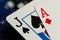 A full frame macro of an Ace of diamonds and a Jack of spades standard playing cards with black and blue betting chips in the