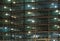 Full frame view of a large construction site at night illuminated by bright work lights with girders and construction hoists