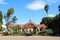 Full, front view of the Botanical Building with pond, flowers, shrubs and trees framing the building in Balboa Park, San Diego