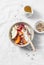 Full fruit and greek yogurt breakfast bowl. Persimmon, apple, walnuts, pomegranates and natural yogurt. Healthy food concept on li
