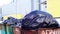 Full garbage containers with large black bags of garbage in wind close-up, near an industrial building. Environmental