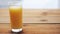 Full glass of orange juice on wooden table