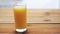 Full glass of orange juice on wooden table