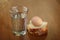 A full glass of water, egg and two slices of bread on scratched old brown wooden table