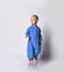Full-growth portrait of walking going towards camera barefooted baby boy in blue fleece jumpsuit with zipper