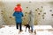 Full height back view unrecognizable portrait with one kid in winter sporty outfit walking outdoors near river
