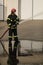 full-height portrait of fireman holds and adjust