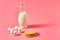Full jug of fresh milk, yogurt or kefir near thin waffles and marshmallow on pink background