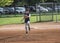 Full length Action photo of a Little League baseball pitcher throwing a pitch