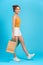 Full length of attractive fashionable girl having fun carrying bargains isolated on bright vivid shine vibrant blue color