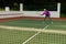 Full length of biracial senior woman hitting tennis ball with racket while playing tennis at court