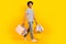 Full length body cadre of young model handsome guy walking purchases bags shopping center addiction isolated on yellow