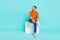 Full length body photo of thoughtful funny model businessman sitting cube look empty space entrepreneur isolated on cyan