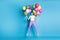 Full length body size photo of amazed girl jumping high with balloons staring with opened mouth isolated on bright blue