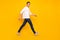Full length body size photo brunet guy smiling confident walking forward isolated vibrant yellow color background