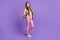 Full length body size photo of cheerful schoolgirl with long hair carrying yellow rucksack isolated on vivid violet