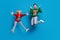 Full length body size photo couple jumping up in ugly xmas sweater shocked amazed isolated bright blue color background