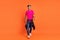 Full length body size photo curious guy in stylish clothes smiling walking forward isolated bright orange color