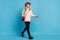 Full length body size photo of curious walking model in red hat beige turtleneck looking copyspace  vivid blue