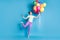 Full length body size photo of girl keeping pile of colorful air balloons smiling standing tiptoes isolated on bright