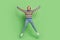Full length body size photo girl in striped sweater jumping up overjoyed laughing isolated pastel green color background