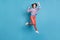 Full length body size photo of jumping cheerfully young girl gesturing like winner isolated on vivid blue color