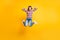 Full length body size photo of jumping high crazy schoolgirl keeping head with hands shouting isolated on vibrant yellow