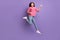 Full length body size photo of jumping high female rocker pretending playing imaginary guitar isolated on vibrant purple