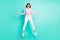 Full length body size photo woman surprised amazed jumping up funny isolated vibrant teal color background