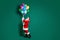 Full length body size profile side view of his he nice attractive handsome Santa holding in hands bunch helium balls