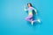 Full length body size view of attractive active purposeful cheerful girl jumping running isolated on bright blue color
