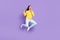 Full length body size view of attractive cheerful crazy girl jumping showing horn sign grimacing isolated over violet