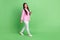 Full length body size view of attractive cheerful girl going using gadget blogging app smm isolated over green pastel