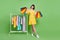 Full length body size view of attractive cheerful girl holding new things closet isolated over green color background