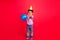 Full length body size view of attractive cheery preteen guy throwing ball having fun isolated over bright red color