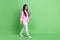Full length body size view of attractive focused cheerful girl going using device chatting isolated over green pastel