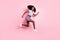 Full length body size view of beautiful trendy active cheerful girl jumping running fast action isolated over pink