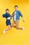 Full length body size view of nice attractive lovely cheerful cheery couple jumping up in air isolated over yellow background