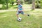 Full length of a boy kicking ball at park