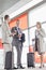 Full length of businesspeople with coffee cups talking on railroad platform