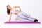 Full length concentrated sportive woman in white sportswear practicing yoga, doing Vasisthasana side plank pose with one hand,