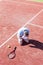 Full length of disappointed mature man with head in hands while kneeling by tennis racket on red court during summer